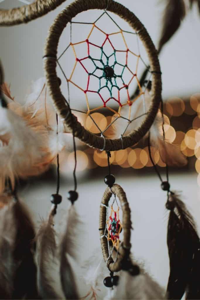 Up close shot of a dream catcher with brown and white feathers