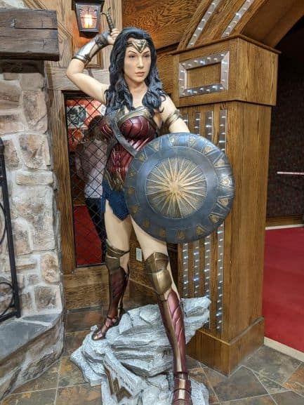 Wax sculpture of Wonder Woman holding her shield out in front of her.