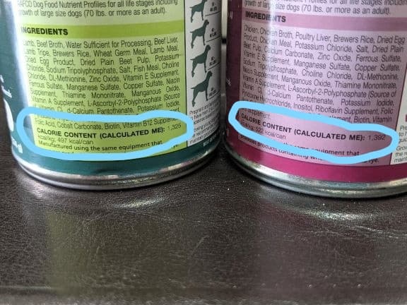 2 cans of dog food by the same brand. The one on the left is lamb and has less calories than the can on right which is made with chicken.