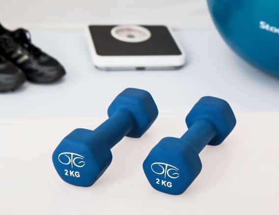 Picture of a set of 2kg blue weights, black tennis shoes, black and white scale, and blue fitness ball