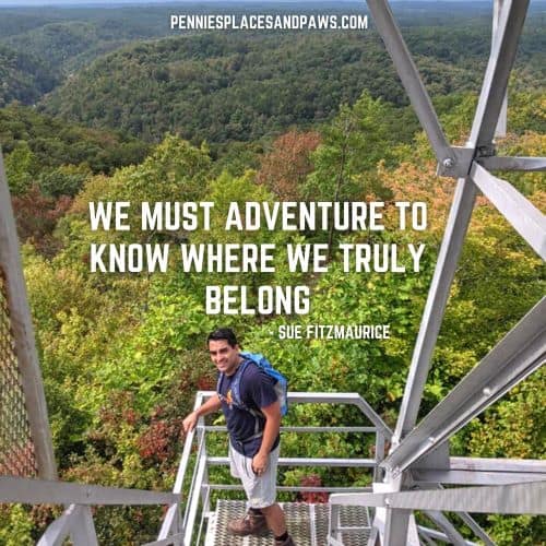 Quote: "We must adventure to know where we truly belong" The Background is a man standing on a fire tower with forest behind him.