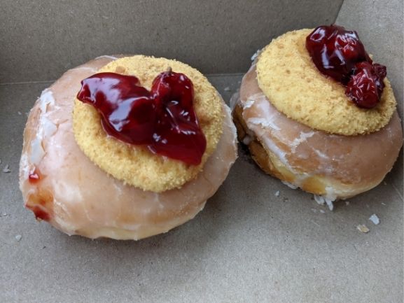 Cherry cheesecake donuts with cheesecake crust crumbs and cherries on top