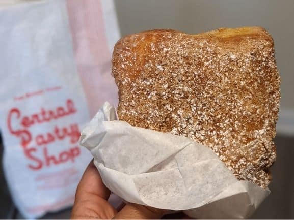 Cinnamon donut square in front of a central pastry shop bag
