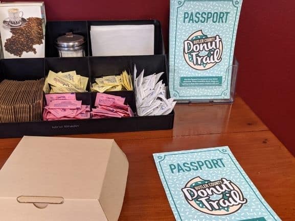 Coffee condiment table with the Butler County Donut Trail Passports available to take