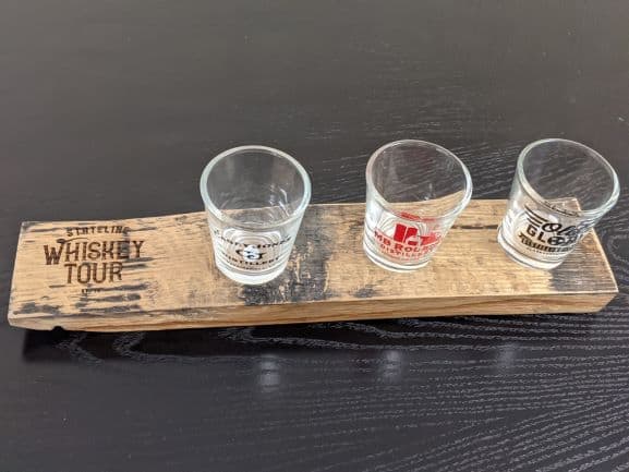 3 shot glasses on a flight paddle that says Stateline Whiskey tour