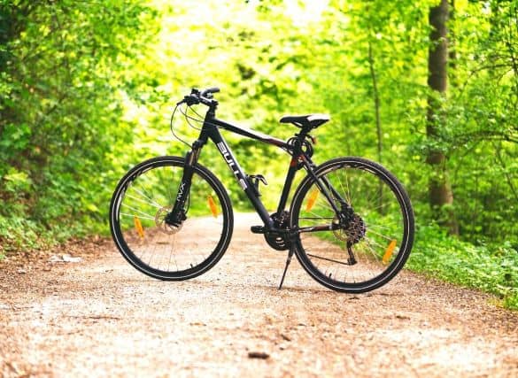 A black bike on a dirt path in the woods