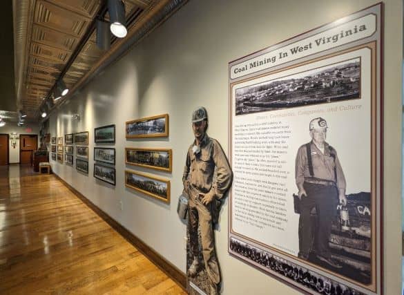 Multiple photos of coal miners in their coal camp groups along with a large infograph giving information about Coal Mining in West Virginia