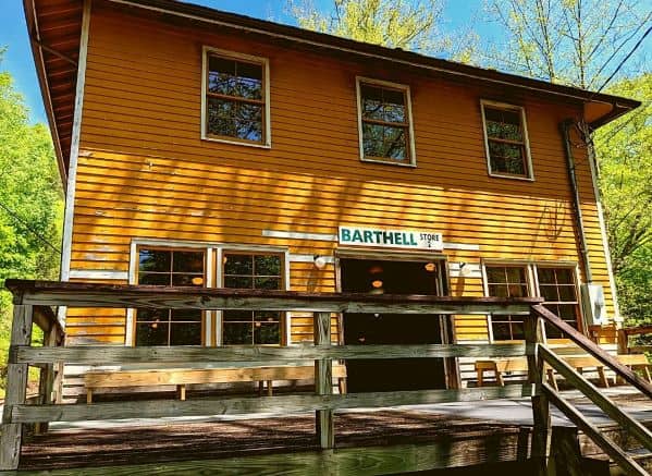 The Barthell General Store. It is yellow and two stories high with a wooden porch around the front.