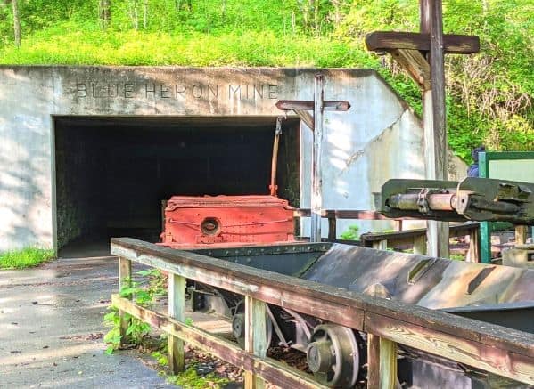 Entrance to the Blue Heron Mine with a coal mining cart on display in front of it.