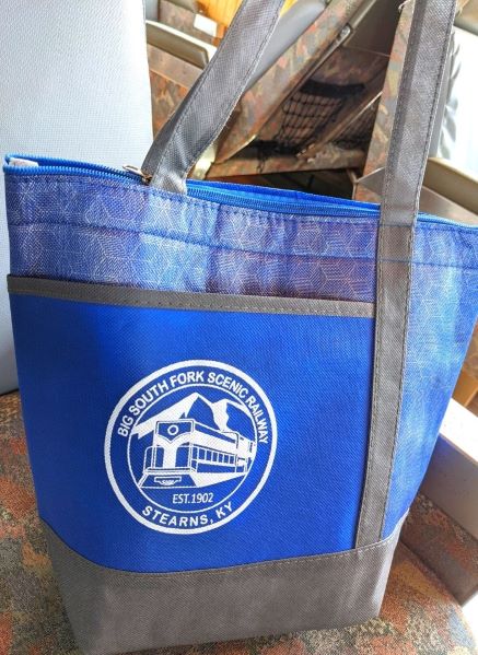 Commemorative blue lunch bag with a white train and words "Big South Fork Scenic Railway  Stearns, KY" written around it