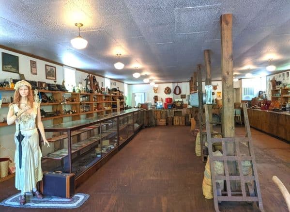 The inside of the Barthell General Store. There is a mannequin along with numerous shelves and display cases full of items from the past.