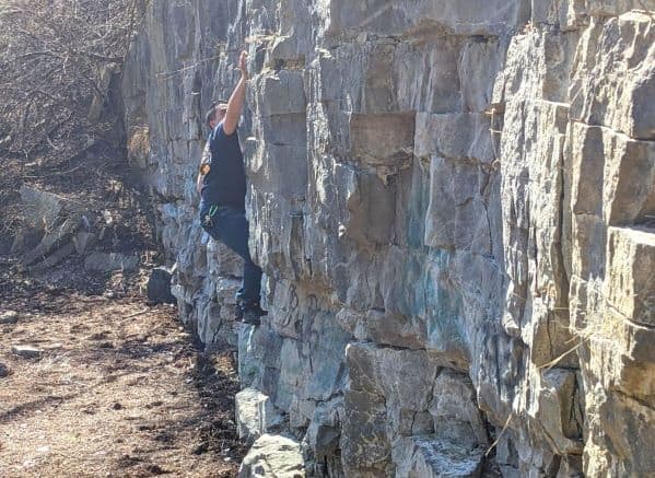 a man climbing on a wall of rock at Blue Creek Metro Park