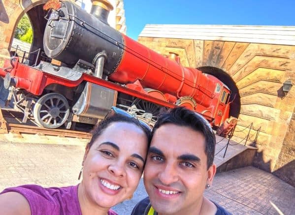 A man and woman taking a selfie in front of the Hogwarts train