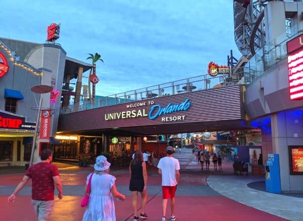 The Welcome Universal Orlando Resort sign. There are people walking under it to enter City Walk