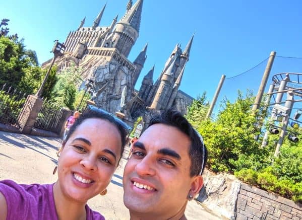 Man and Woman smiling in front of Hogwarts Castle at Universal Orlando Resort