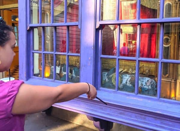 Woman pointing the wand at one of the spell locations in Harry Potter World