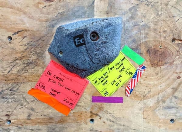 One of the climbing rocks labelled with tape stating what climbing routes it is a part of