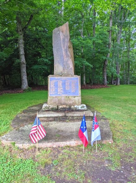 Memorial in Droop Mountain State Park. Its is tall tower like structure with American, Union, and Confederate flags displayed in front of it.