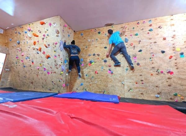 A man and woman climbing on the bouldering wall in Climb Toledo