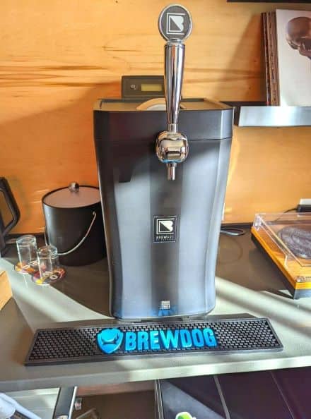 Personal Beer Tap in the room at DogHouse Hotel. A beer mat is in front of tap that has Brewdog logo and also says BREWDOG in bright sky blue.
