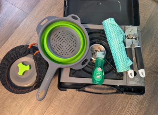 camping stove, can opener, strainer, posts, dishwashing soap and compostable rag