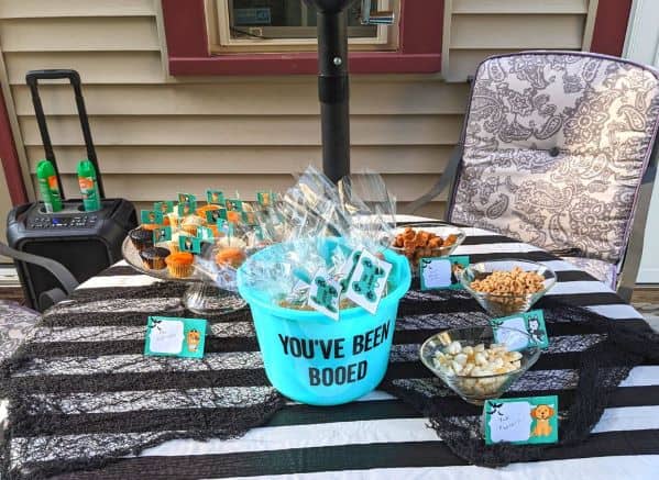 Halloween table full of dog snacks labeled with themed food tent labels