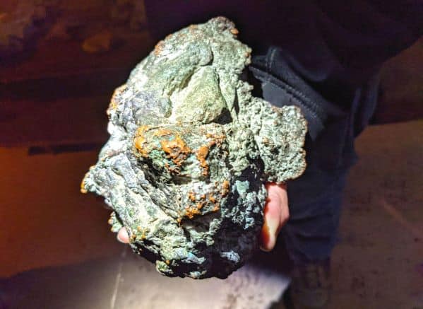 Copper in rock left behind in mine held by tour guide 
