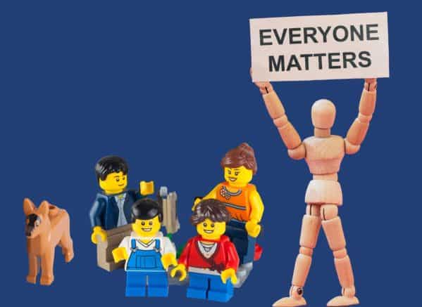 Lego family and their dog next to a sign that says everyone matters