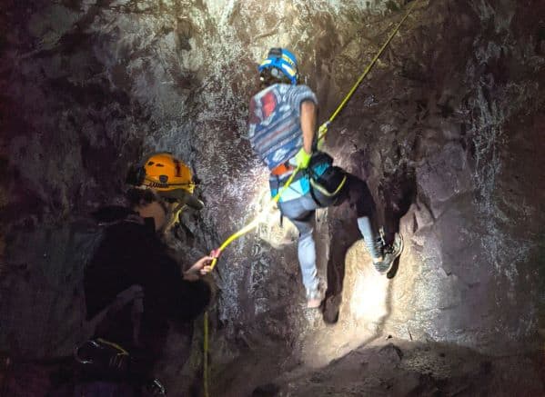 Woman rappelling down into a copper mine