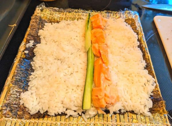 rice, cucumbers, and smoked salmon on an open seaweed wrap