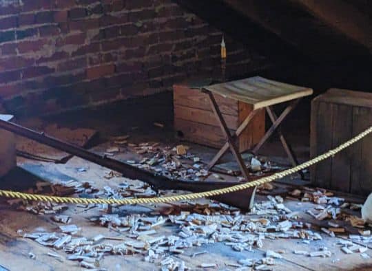 close up of rifle and discarded cartridges  in attic of Shriver House