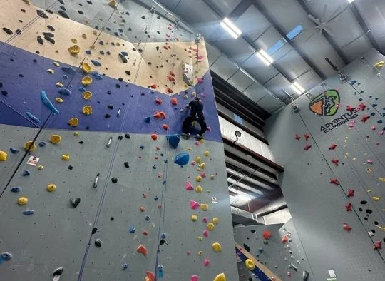 Person climbing on auto belay wall in Adventus Climbing Toledo