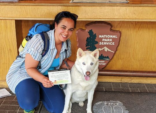 Dog and Woman in front of National Park Service Sign