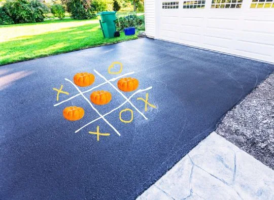 Pumpkin Patch Paw Game set up on a driveway (Tic Tac Toe with pumpkins)