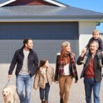 family of four with dog visiting their parents on driveway