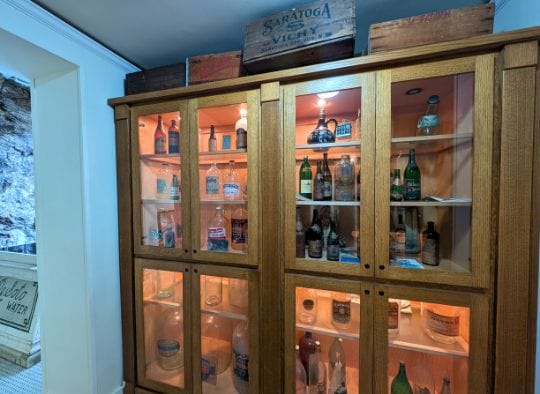 Wall Exhibit of Old bottles from different water companies