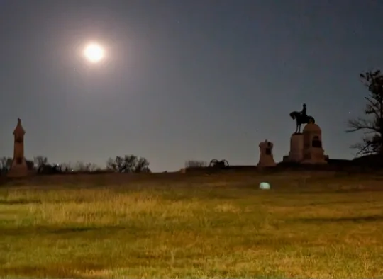 An orb near some memorial stones in Gettysburg Battlefield during a ghost tour